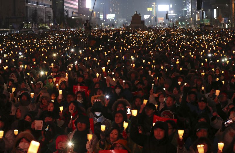 In this Nov. 26, 2016 photo, South Korean protesters hold up candles and smartphones' light during a rally calling for South Korean President Park Geun-hye to step down in Seoul, South Korea. South Korean protesters in capital Seoul take part in candlelight vigils demanding the ouster of Park, who is suspected of assisting criminal activities of a secretive confidante who allegedly manipulated power from the shadows and extorted companies to amass an illicit fortune. (AP Photo/Lee Jin-man)