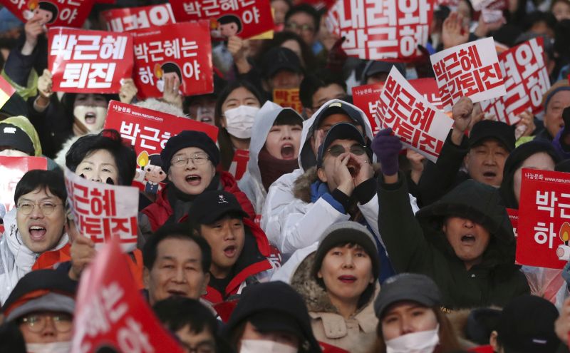 South Korean protesters shout slogans during a rally calling for South Korean President Park Geun-hye to step down in Seoul, South Korea, Saturday, Nov. 26, 2016. For the fifth-straight weekend, masses of protesters are expected to occupy major avenues in downtown Seoul on Saturday demanding the ouster of Park who is suspected of helping in the criminal activities of a secretive confidante who is accused of manipulating government affairs and extorting companies to build an illicit fortune. The signs read "Park Geun-hye, Step down." (AP Photo/Lee Jin-man)
