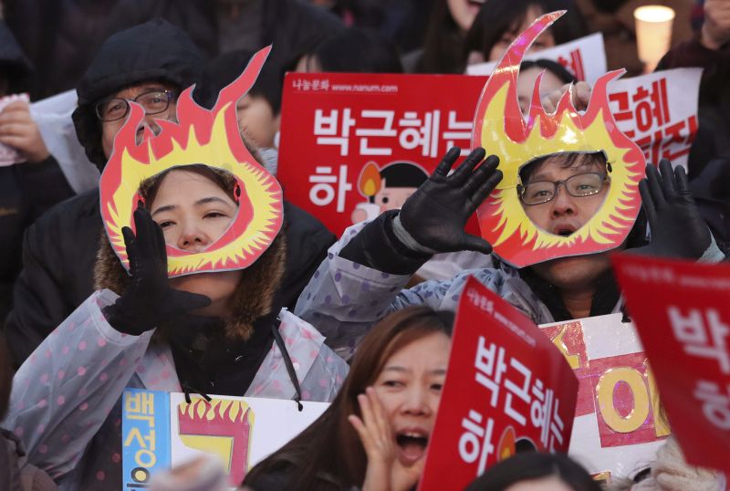 South Korean protesters shout slogans during a rally calling for South Korean President Park Geun-hye to step down in Seoul, South Korea, Saturday, Nov. 26, 2016. For the fifth-straight weekend, masses of protesters are expected to occupy major avenues in downtown Seoul on Saturday demanding the ouster of Park who is suspected of helping in the criminal activities of a secretive confidante who is accused of manipulating government affairs and extorting companies to build an illicit fortune. The letters read "Park Geun-hye, Step down." (AP Photo/Lee Jin-man)